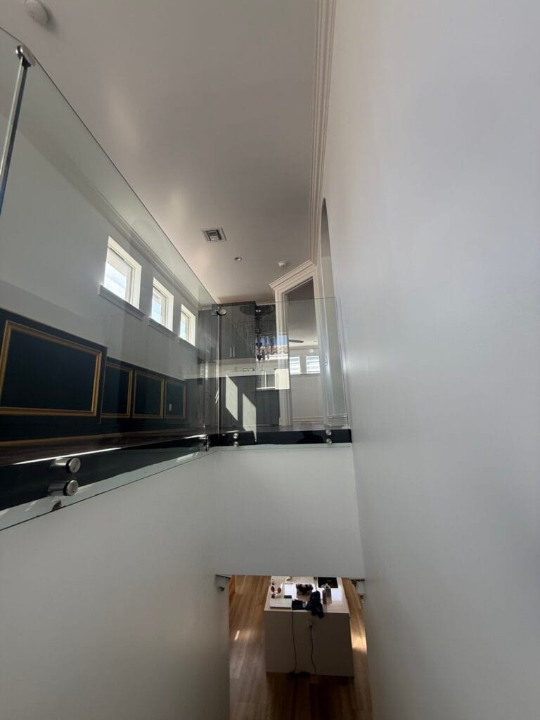 Frameless glass landing and balcony railing overlooking the kitchen, Boca Raton